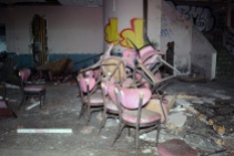 Pile of chairs in trashed dining area