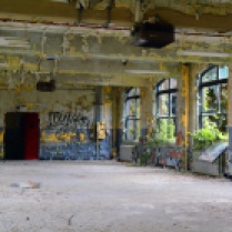 Large open room with lots of windows and colorful peeling paint
